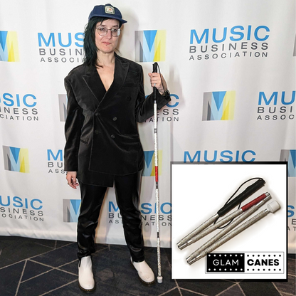 A white woman poses confidently holding a rhinestone glam cane with a silvery white and red design